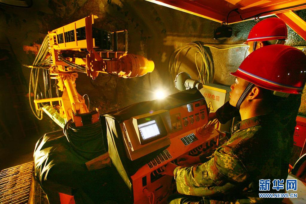 火箭軍某部官兵在掘進(jìn)作業(yè)中操作全電腦鑿巖臺(tái)車鉆孔（2014年4月12日攝）。新華社發(fā)（方雷 攝）